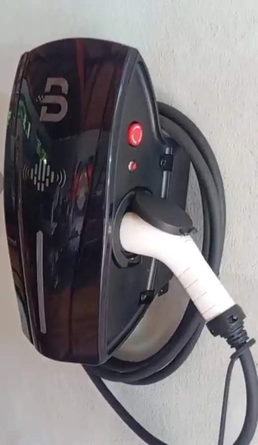 Wall-mounted electric vehicle charging station with charging cable connected