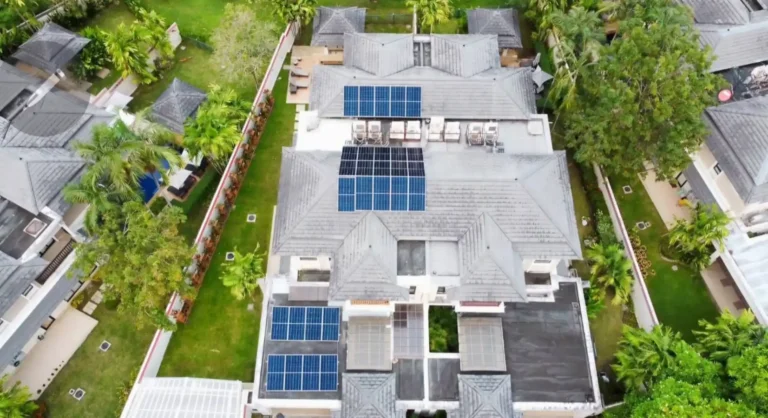 Aerial view of multiple rooftop solar panel installations on a residential property