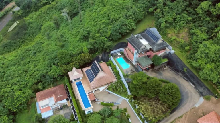 Solar panel system installed on hillside homes surrounded by tropical vegetation